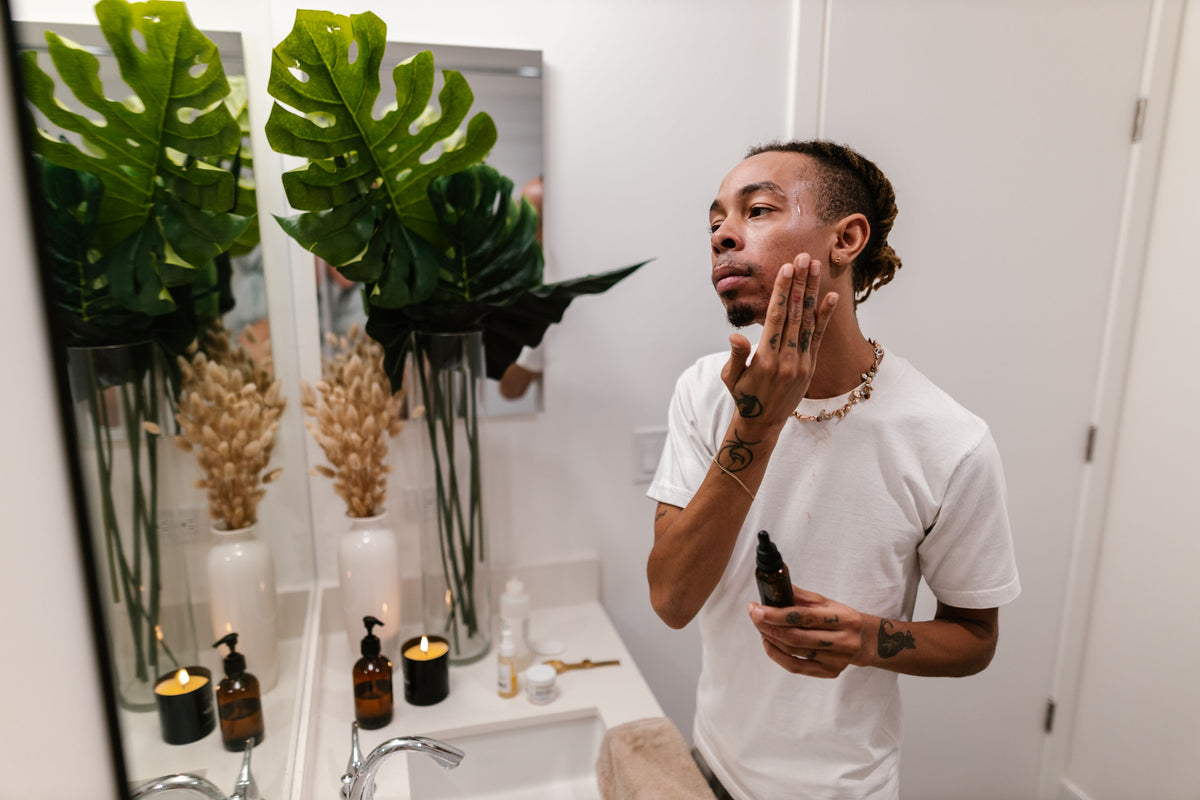 Man applying facial serum during an evening skincare ritual