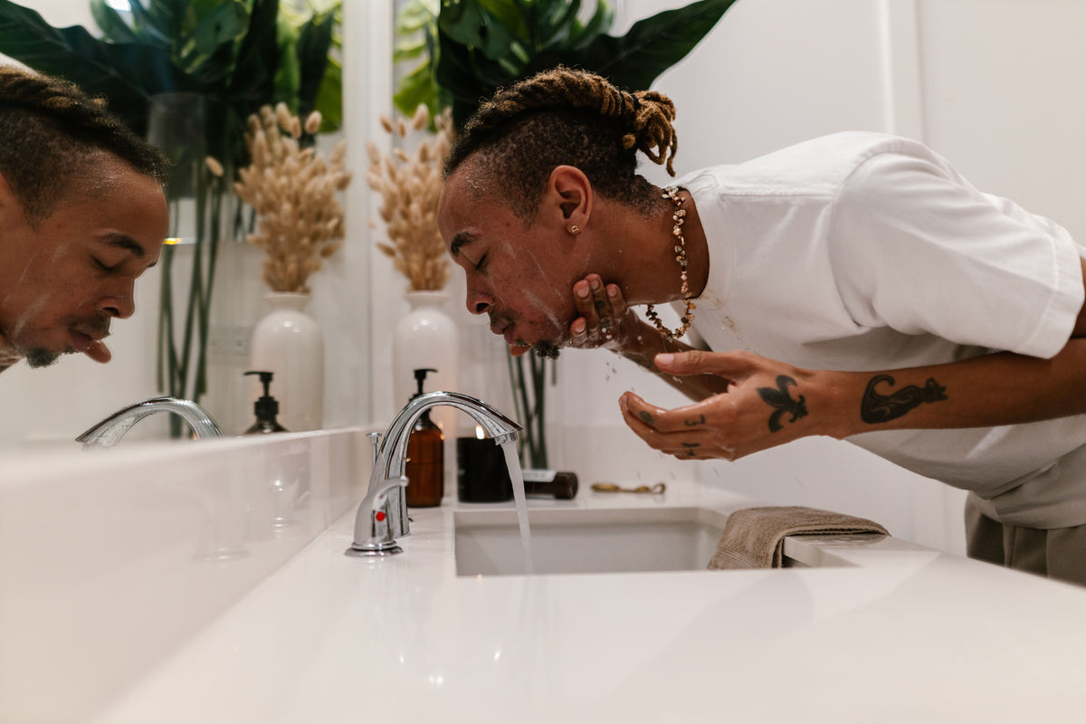 Man cleansing his face as part of a simple skincare ritual