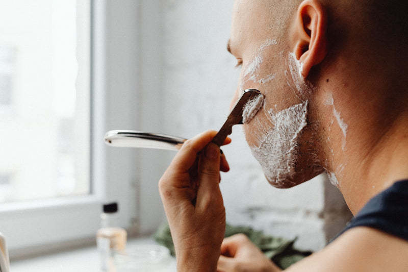 Man shaving his face with a razor illustrating shaving and skin barrier care